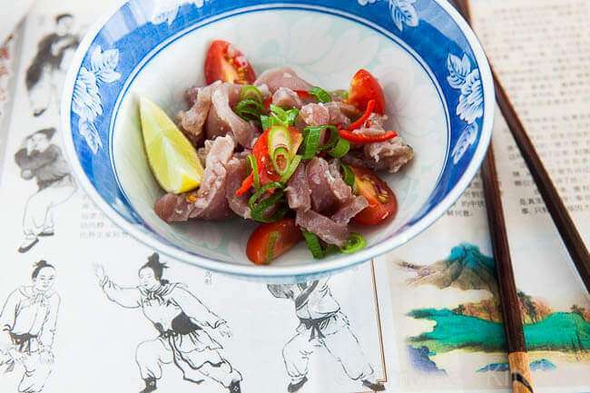 Bowl of tuna ceviche on a Chinese newspaper