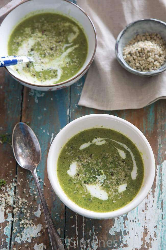 Top shots of two bowls of broccoli spinach soup with coconut milk