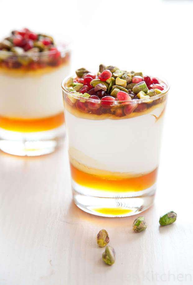 Yogurt and pomegranate dessert with honey. Two glasses with backlight