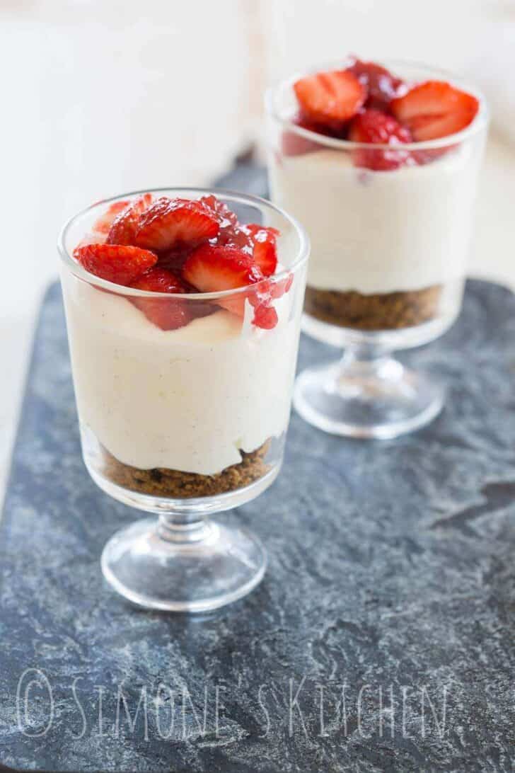 Two glasses on a serving plate with cheesecake