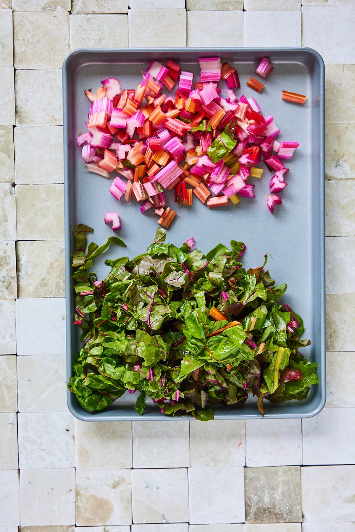 Chopped swiss chard with stems and leaves divided on a board
