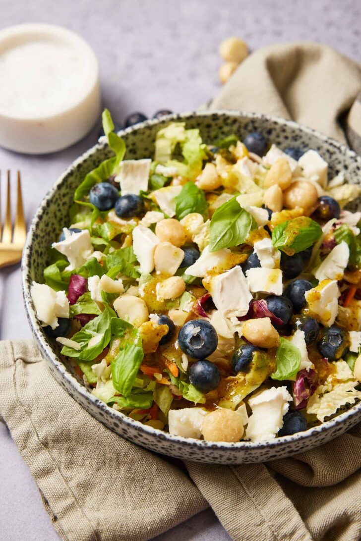 salad with goat cheese with the dressing sprinkled on top