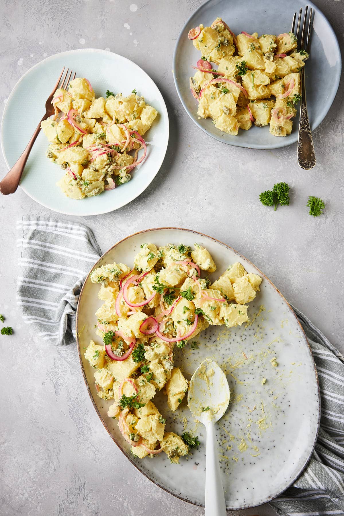 Classic potato salad on a plate with two smaller plates