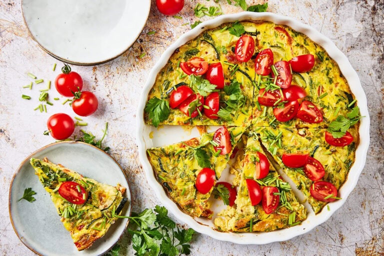 Zucchini quiche in quiche form with plate