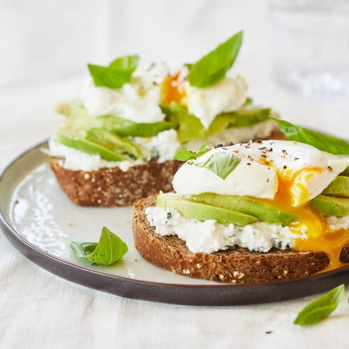 Avocado toast with egg and ricotta with fresh basil on top