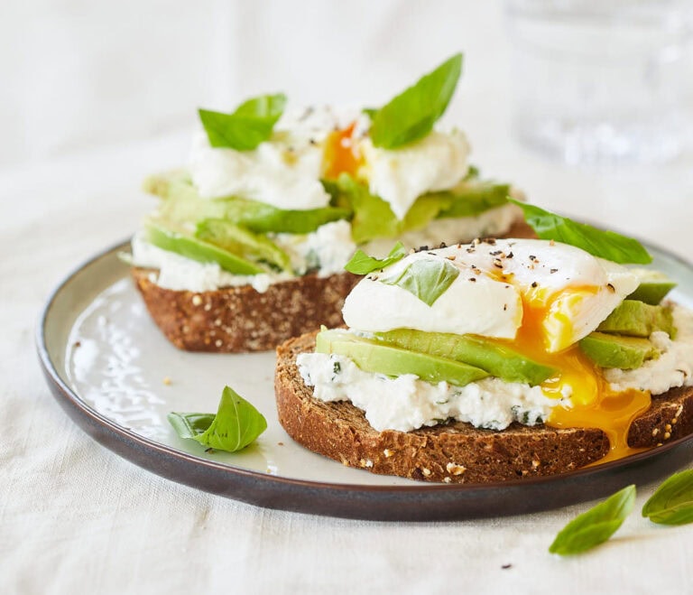 Avocado toast with egg and ricotta with fresh basil on top