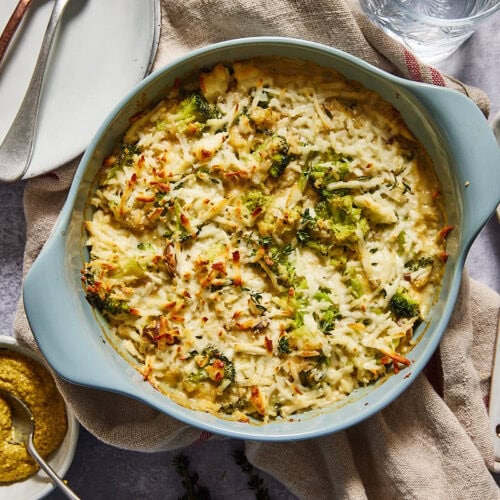 Broccoli cheese casserole on a table with empty plates