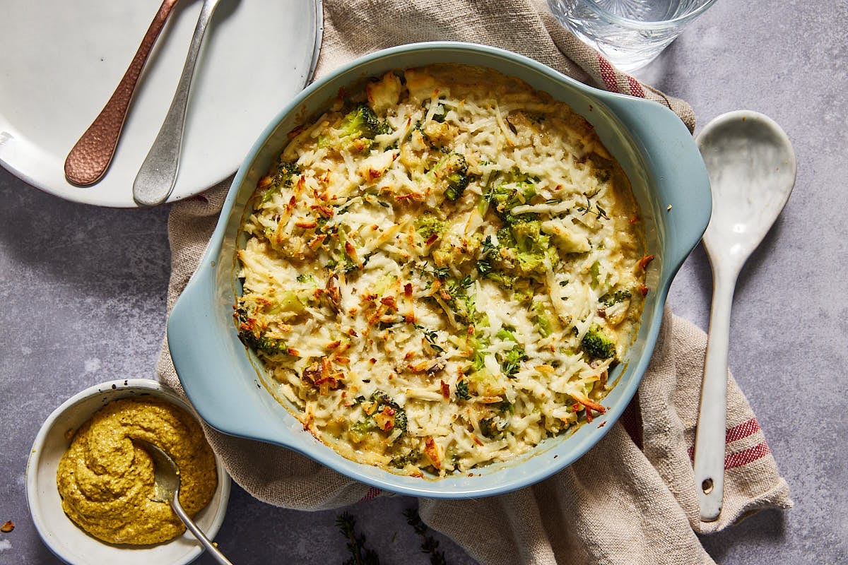 Broccoli cheese casserole on a table with empty plates
